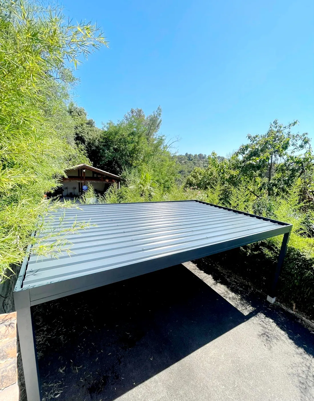 Carport aluminium moderne sur mesure intégré dans un jardin